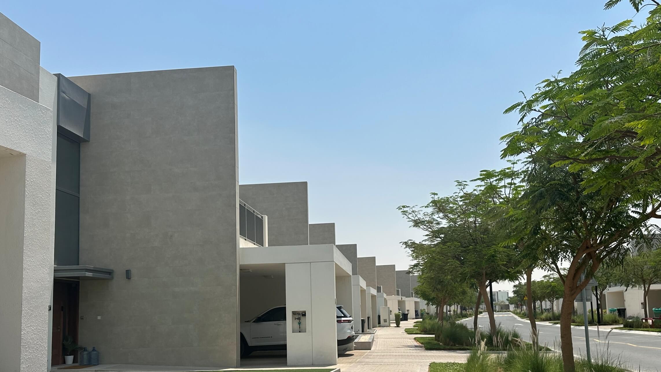 Contemporary white villas with covered garages and landscaped sidewalks in the Golf Links community at Emaar South, Dubai South, UAE