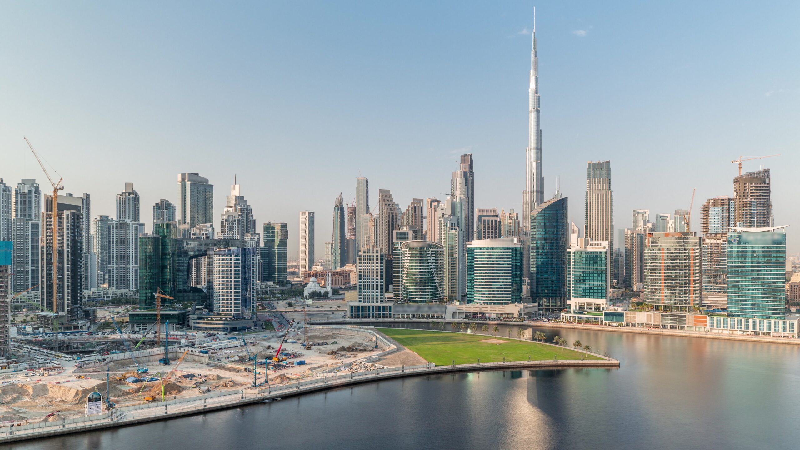 Business Bay canal promenade with Downtown Dubai skyline and Burj Khalifa in the distance, Dubai, UAE